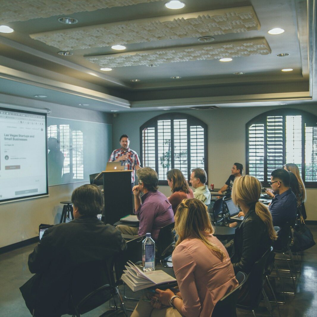 a group of people in a room with a projector screen